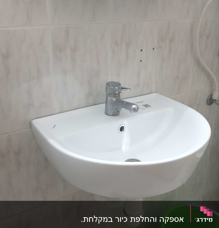 כיור עם ברז, דלי ירוק וצינור ניקוז